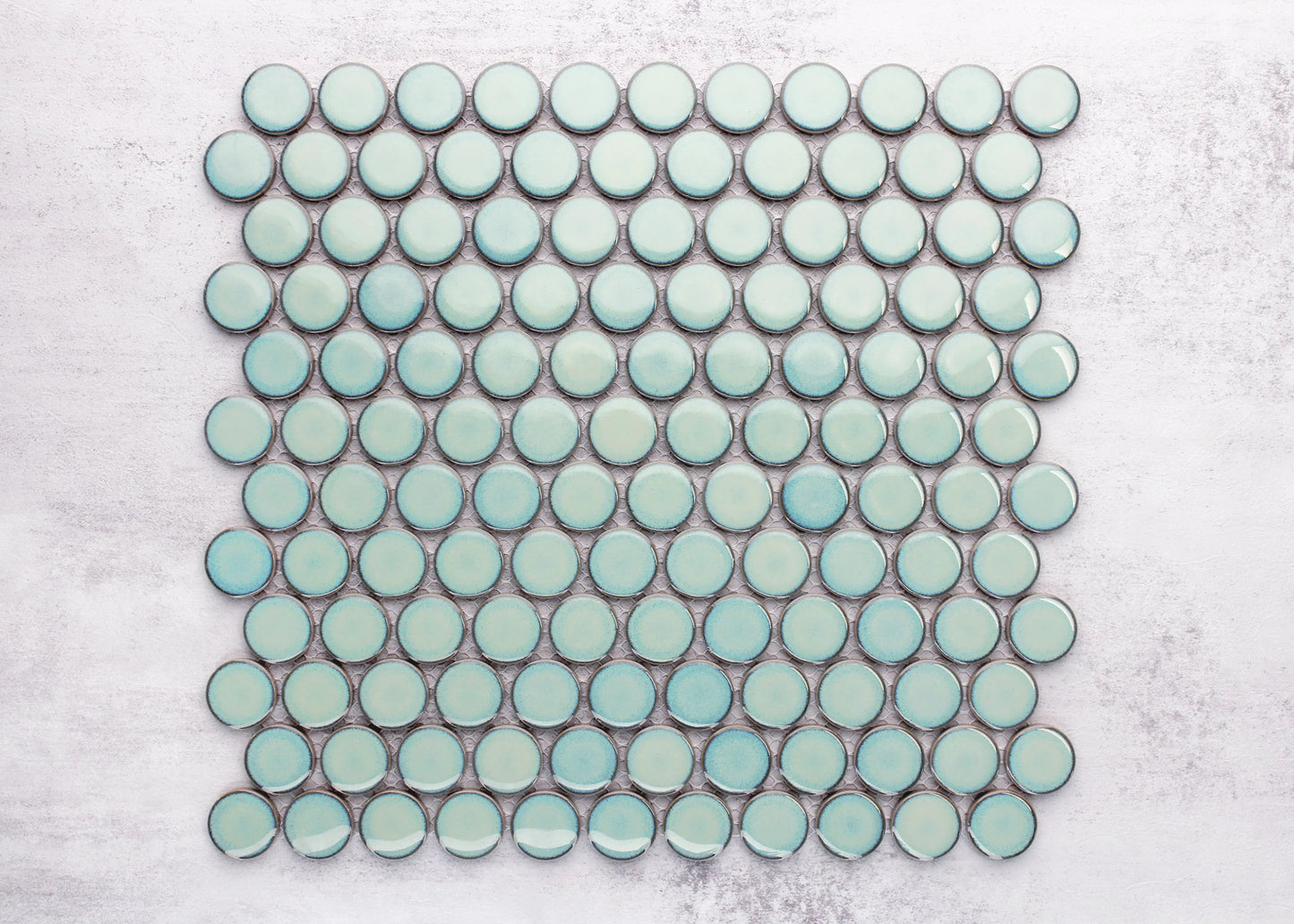 A mosaic sheet of Antique Green Gloss Glazed Porcelain Penny Round 28mm Diameter tiles arranged in a grid pattern, showing their glossy aqua-mint finish and circular shape.