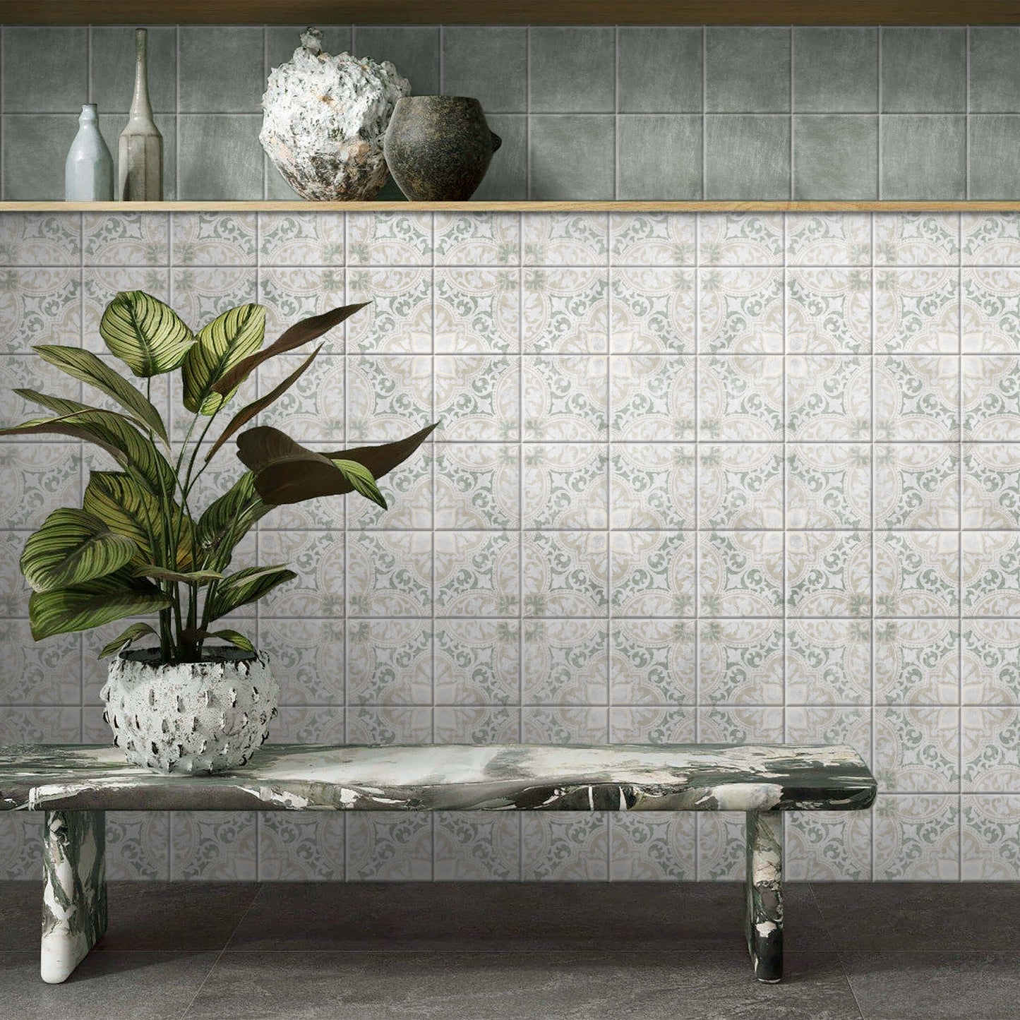 Antiquity Valencia Verde Decor 150x150mm decorative patterned wall tiles in soft grey-green and cream tones, styled with a marble bench and tropical potted plant.