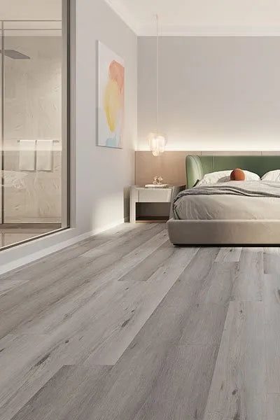 Ash Cliff Elegant SPC Hybrid 6.5mm Flooring 5+1.5mm installed in a modern bedroom featuring grey wood-look planks, a green upholstered bed, pendant lights, and an ensuite bathroom.