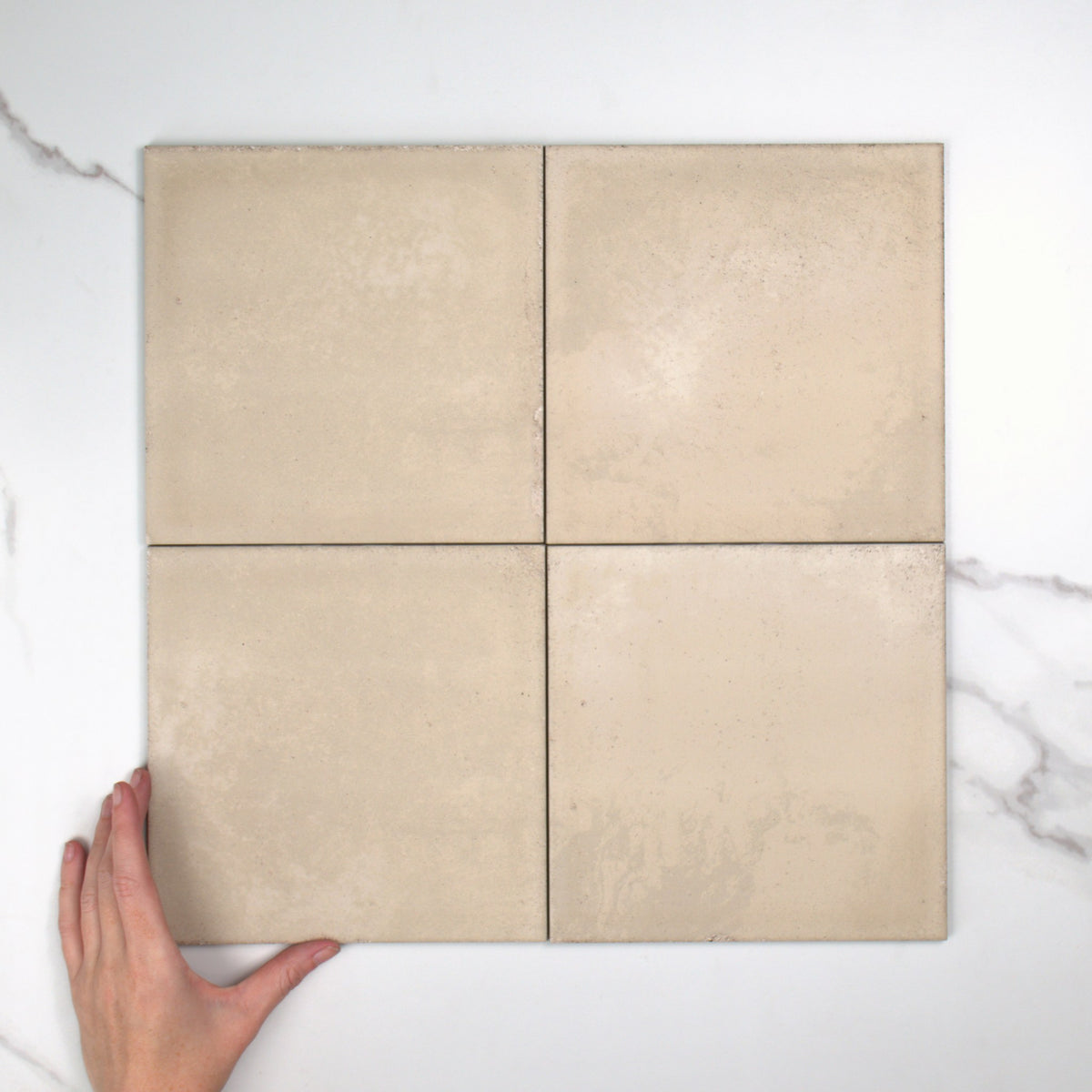 Atlantique Amande Matt 200x200mm top view, hand for scale