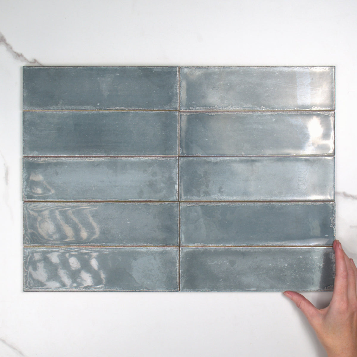 Atlantique Bleu Gloss 69x240mm top view, hand for scale