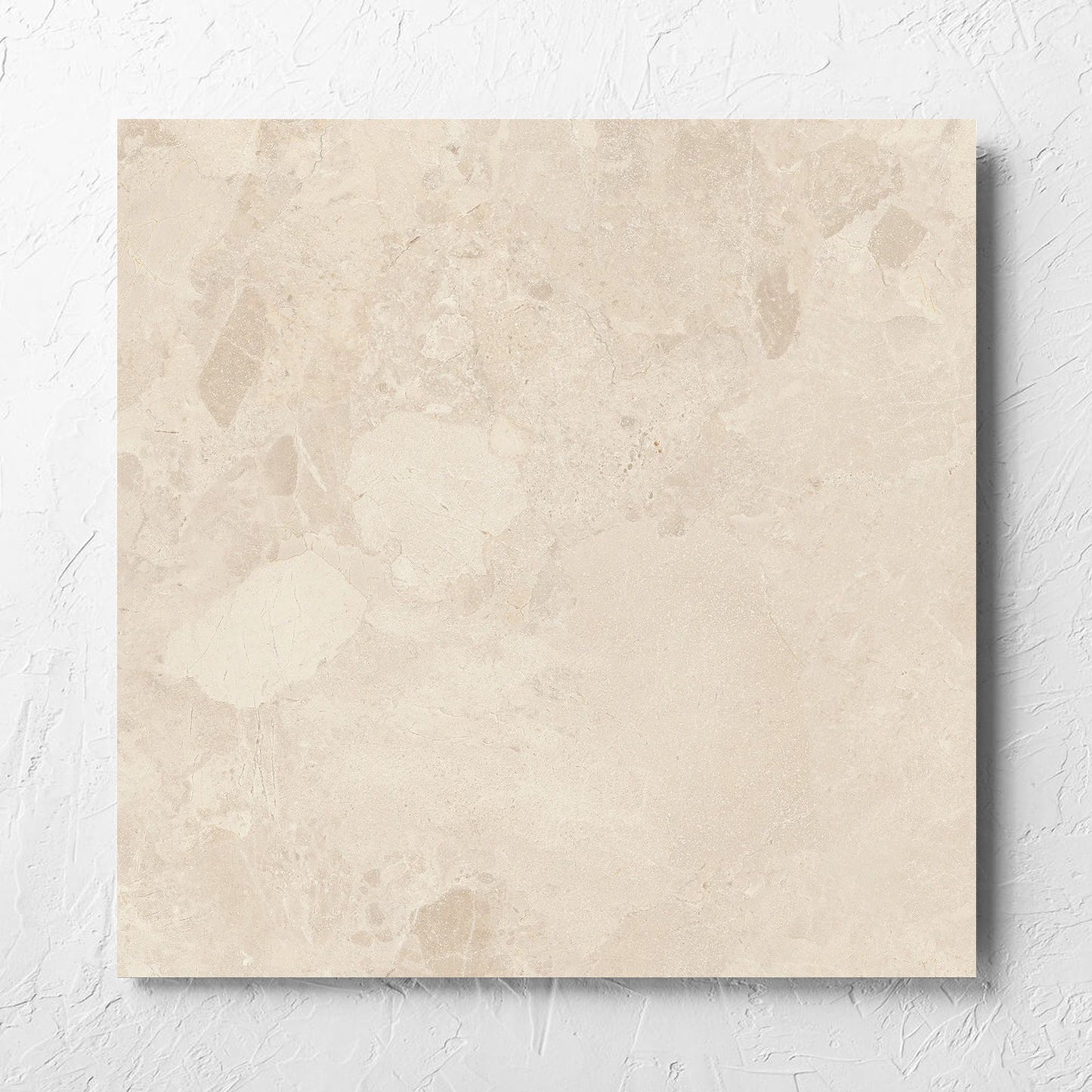 Aurelia Stone Almond Matt 600x600mm tile laid flat on a white rendered wall, showing the matt surface