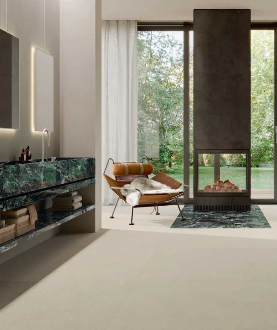 Balance Ivory Matt 600x1200mm floor tiles installed in a luxury open-plan bathroom featuring a green marble vanity, leather lounge chair, and floor-to-ceiling windows.