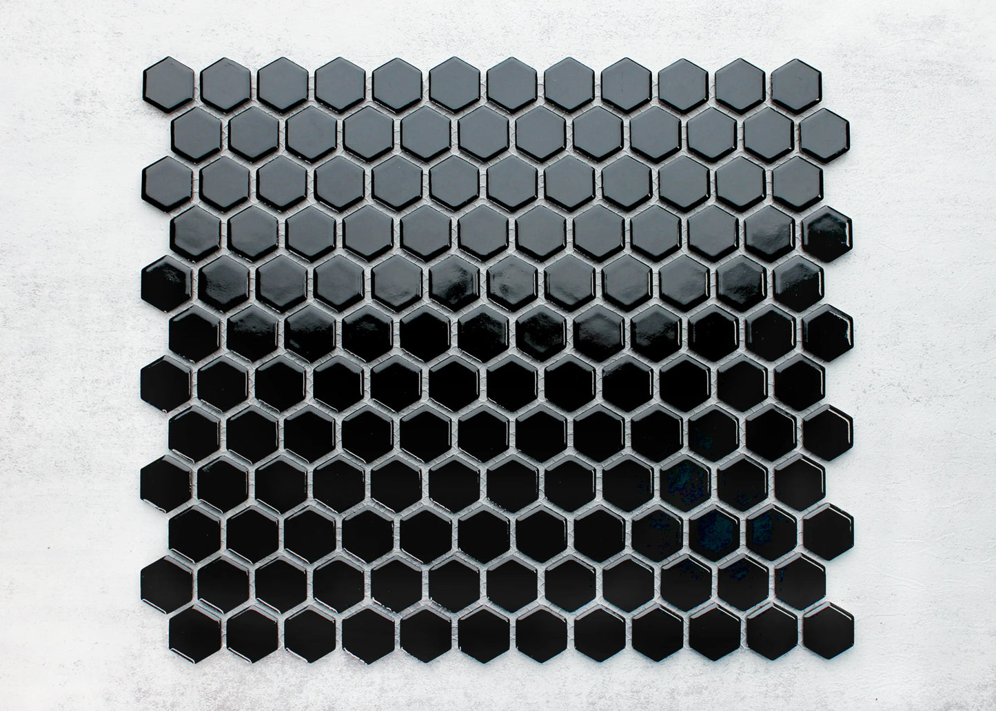 Black Gloss Porcelain Glazed Hexagon 23mm mosaic sheet displayed flat, showing a gradient from dark grey to deep gloss black small hexagonal tiles.