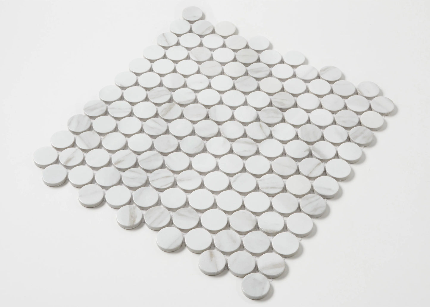 Pack shot of Carrara Look Matte Glazed Porcelain Penny Round 28mm Diameter tiles arranged in a diamond shape, showing white marble-effect circular discs with subtle grey veining.