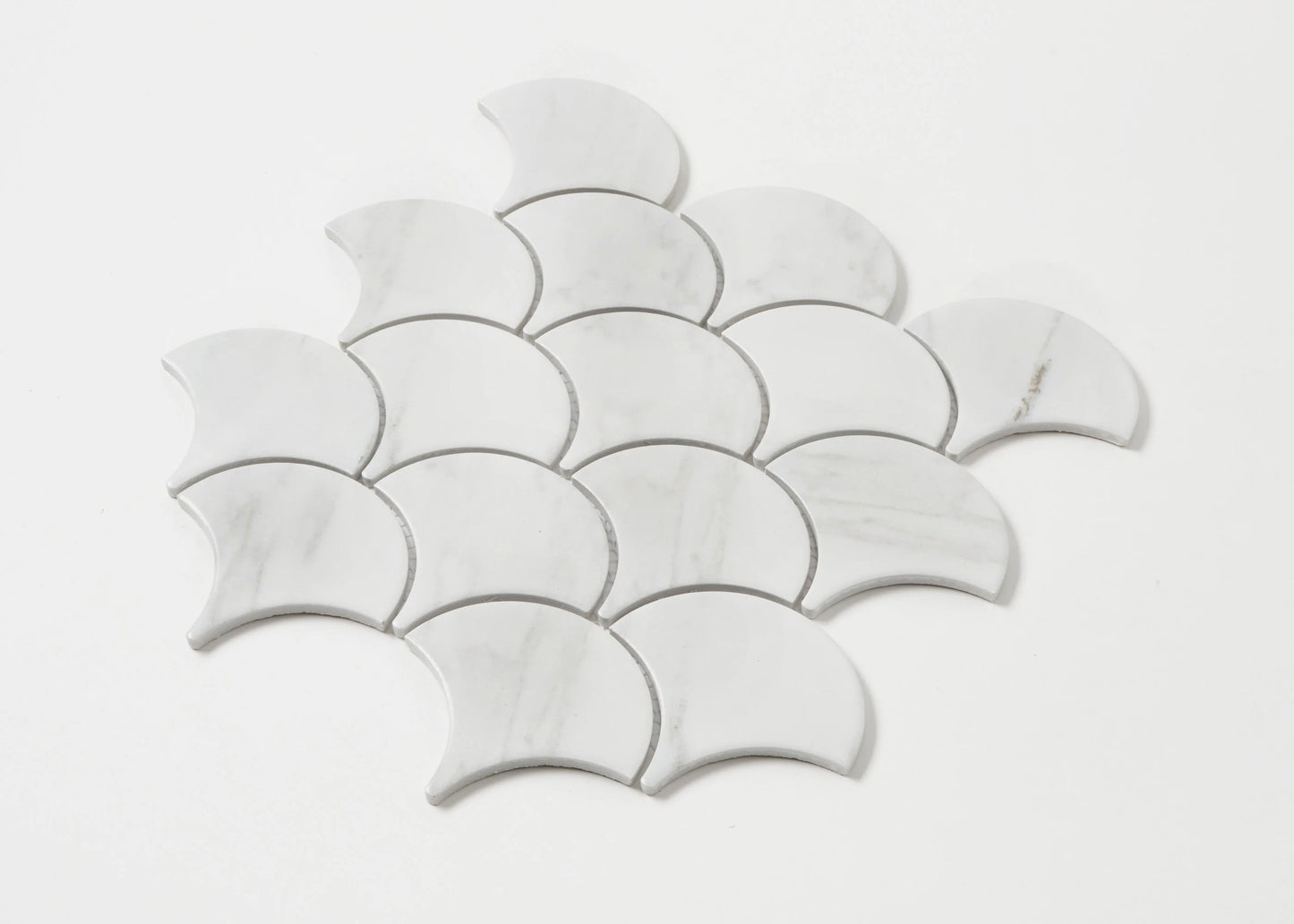 Pack shot of Carrara Look Matte Porcelain Glazed Fishscale 95x87mm tiles arranged in an overlapping scale pattern, showing white marble-effect finish with subtle grey veining.
