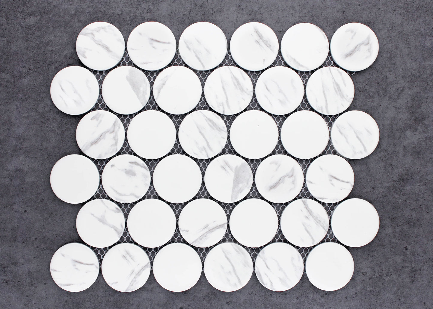 Carrara Look Matte Porcelain Glazed Penny Round 48mm tiles arranged on a mesh sheet, showing white matte circular tiles with subtle grey marble veining.