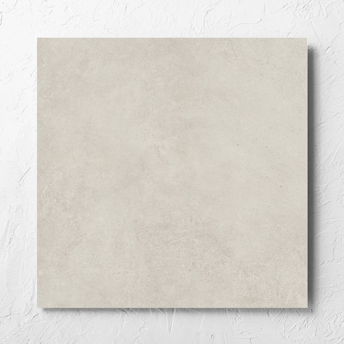 Cement Light Grey Matt 600x600mm tile laid flat on a white rendered wall, showing the matt surface