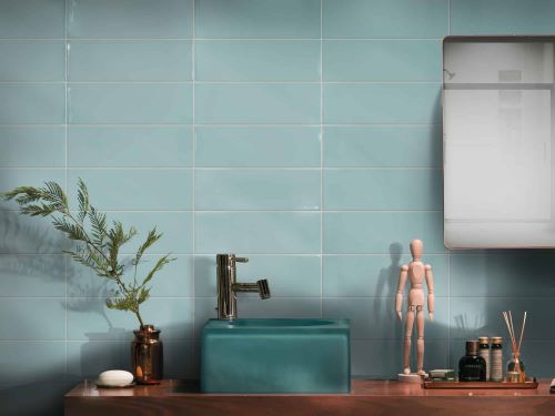 Cucina Tiffany Blue Gloss 100x300mm tiles installed as a full bathroom wall behind a teal vessel sink on a timber vanity shelf.