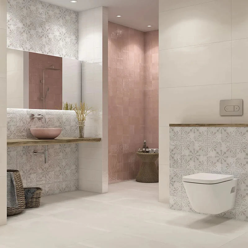 Dune Giuliana 147x147mm patterned wall tiles in a soft white and grey floral finish, styled in a modern bathroom with a pink vessel sink, timber vanity, and wall-hung toilet.