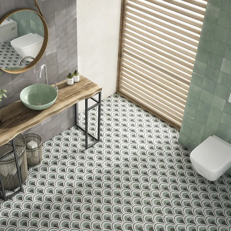 Dune Marina 147x147mm scallop-pattern floor tiles in sage green and white installed in a modern bathroom with round mirror and vessel sink vanity.