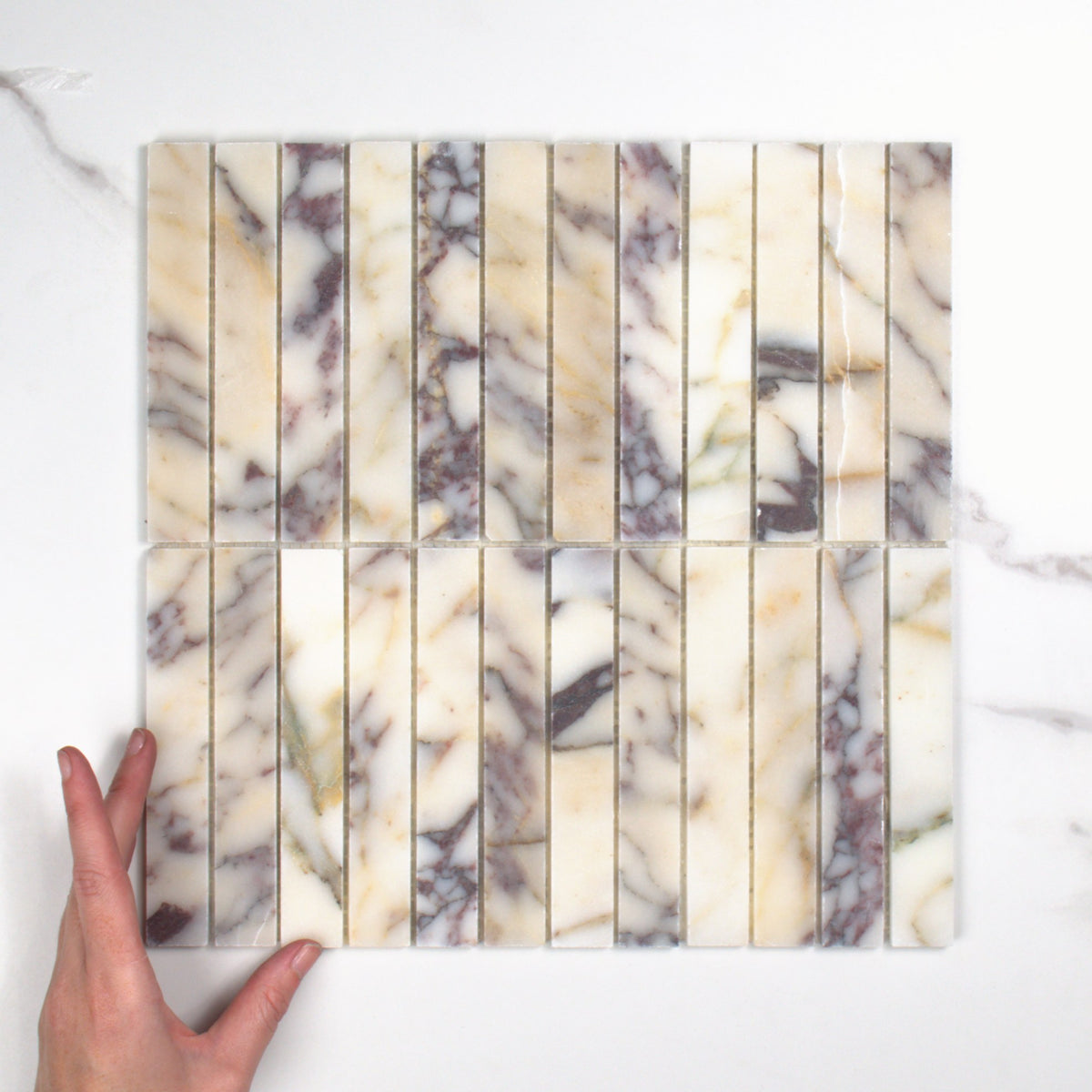 Elementa Calacatta Viola Finger Mosaic 23x148mm top view, hand for scale