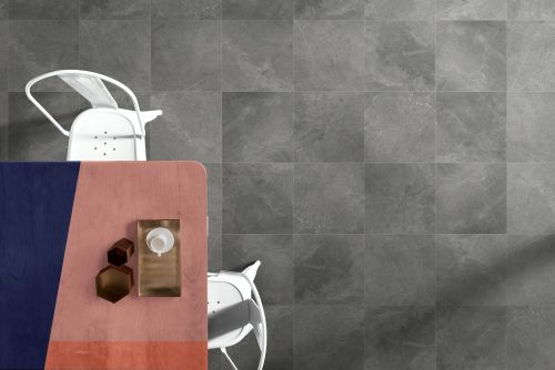 Kashmir Stone Matt 450x450mm grey stone-effect floor tiles installed in a modern dining area with a pink table and white metal chairs viewed from above.