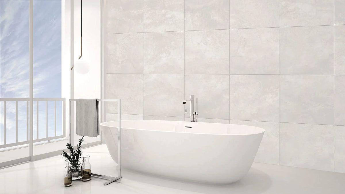 Kensington White Matt 300x600mm tiles covering a full-height bathroom wall behind a freestanding white soaking tub with chrome filler and pendant light.