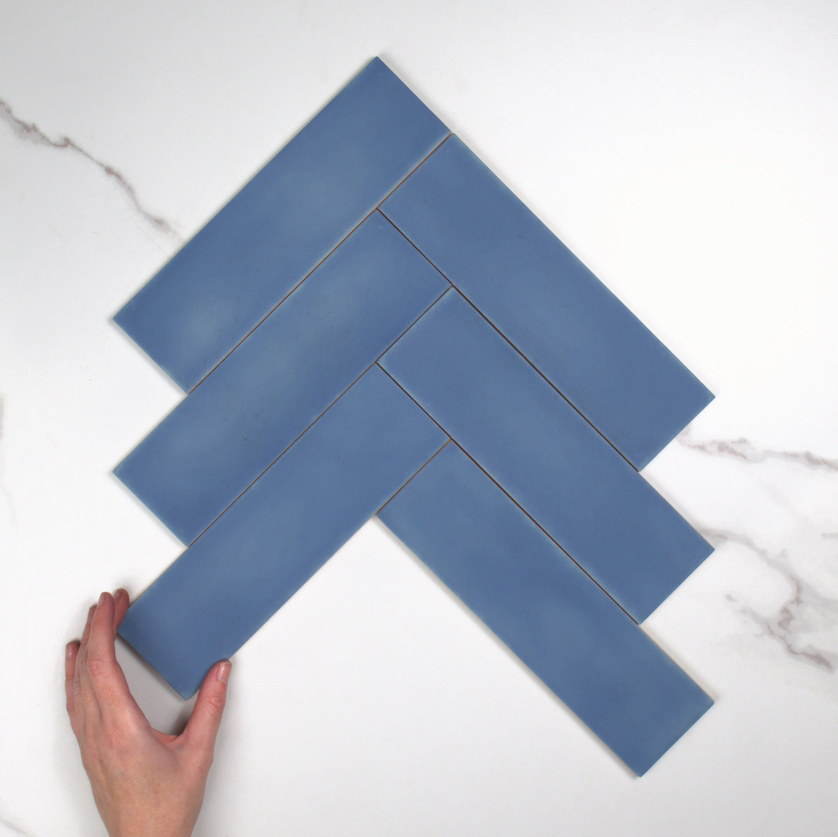 Milano Blu Matt 69x240mm top view, hand for scale