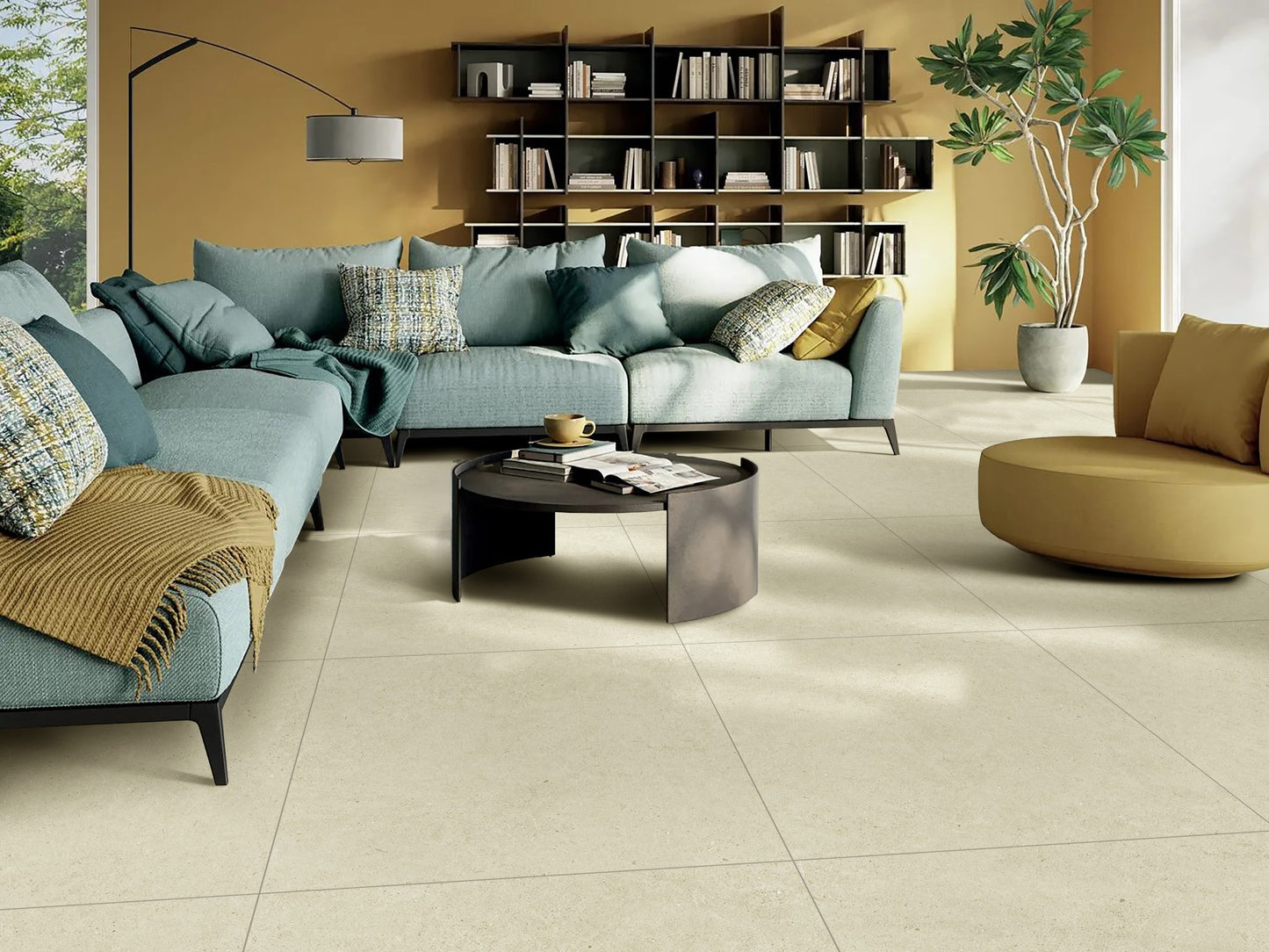 Organic Pietra Lavica Birch 300x600mm large-format cream floor tiles installed in a modern living room with a teal sectional sofa and mustard yellow walls.