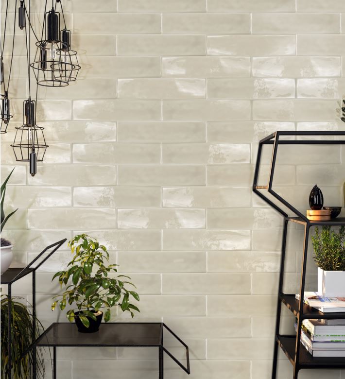Pasha Mist Gloss 75x300mm cream glazed brick-format wall tiles installed in a styled living space with industrial pendant lights and metal shelving.