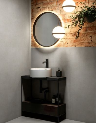 Serenity Urban Stone In/Out 450x450mm matte grey tiles on bathroom walls paired with a round backlit mirror, black vanity unit, and globe pendant lights.