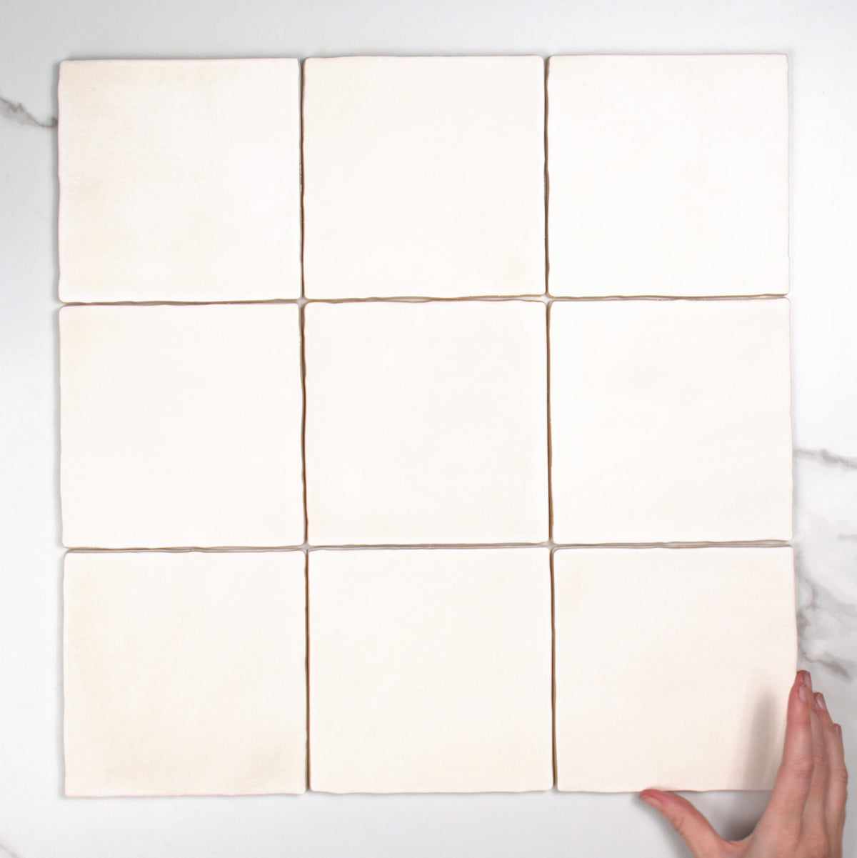 Tabarca Blanco Matt 150x150mm top view, hand for scale
