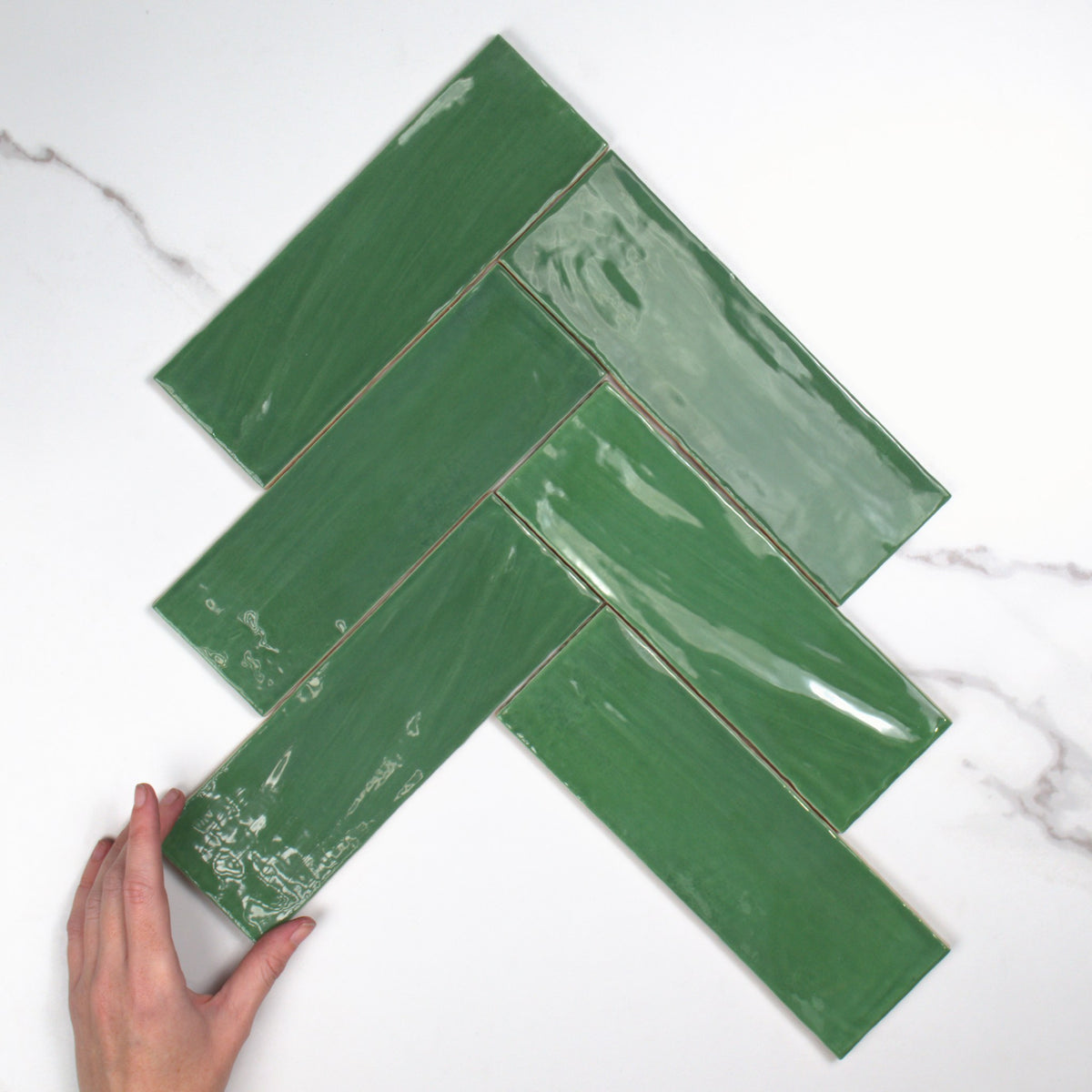 Tabarca Verde Gloss 75x230mm top view, hand for scale