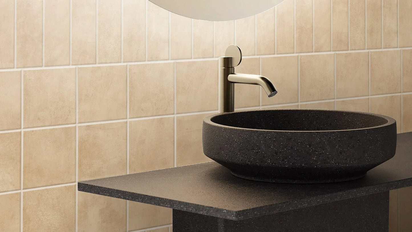 Terracota Blanco 200X200mm cream wall tiles installed vertically behind a dark stone vessel sink and brushed steel faucet on a black vanity countertop.