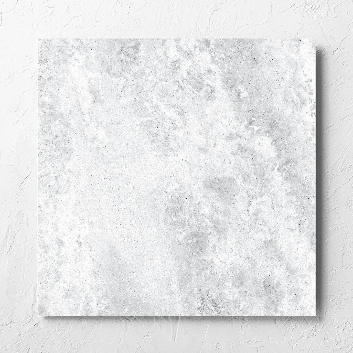Vatican White Cross Cut Travertine 600x600mm tile laid flat on a white rendered wall, showing the matt surface
