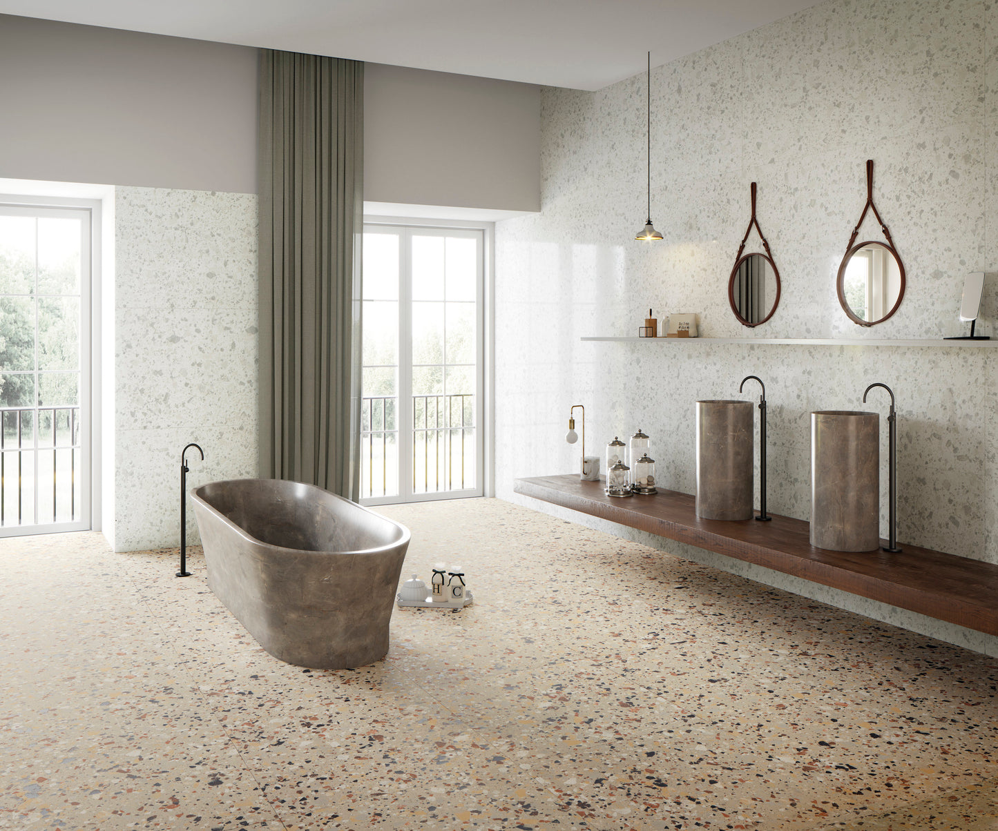 Venice Zinc 300x600mm Matt Terrazzo Tile covering the floor and walls of a spacious luxury bathroom featuring a freestanding stone bath, twin pedestal basins, and round leather-framed mirrors.