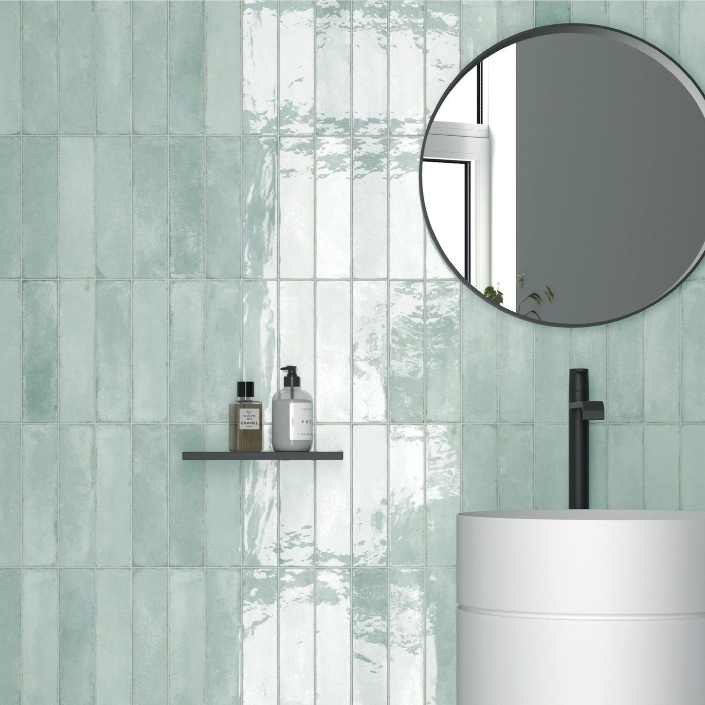 Acquarello Aqua Glossy 60x246mm tiles covering a bathroom feature wall in soft mint green with a round black-framed mirror and cylindrical white basin.