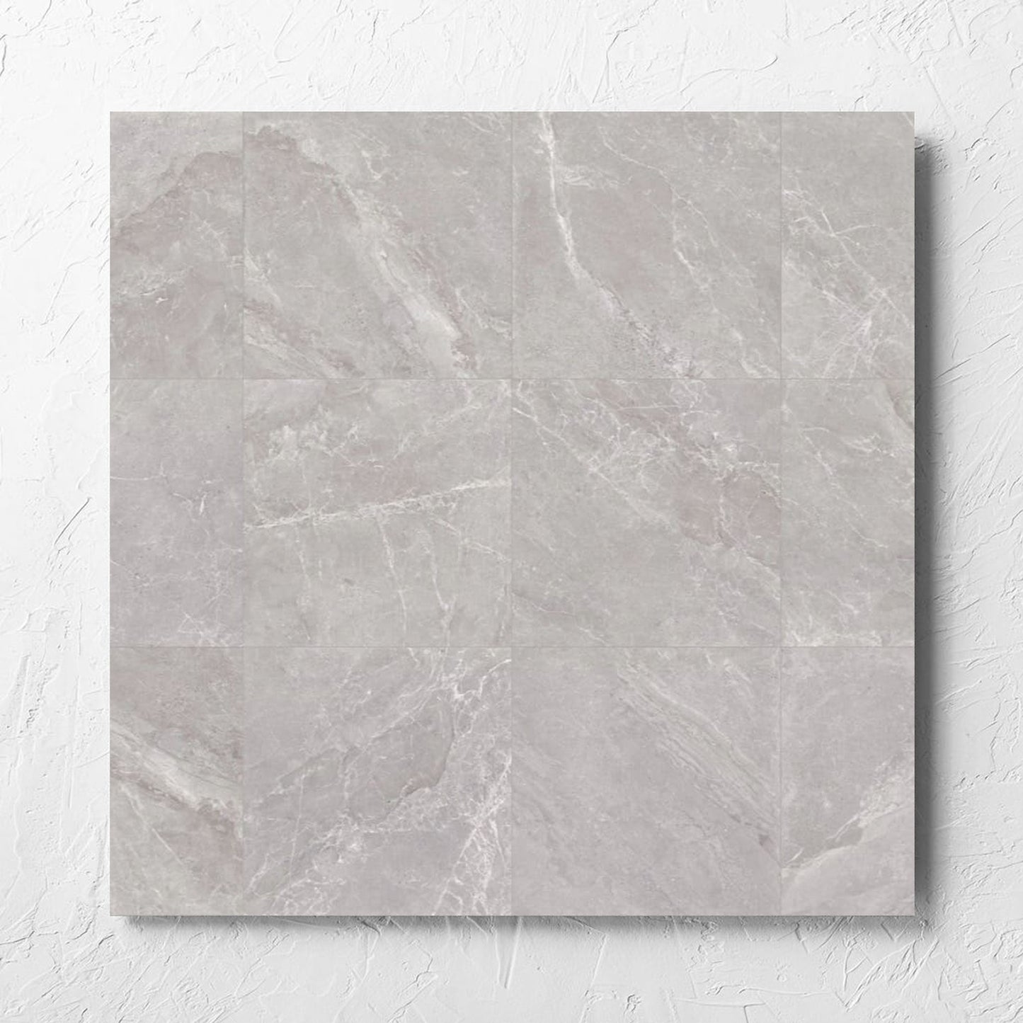 Alpen Stone Grey 600x600mm tile laid flat on a white rendered wall, showing the tile surface