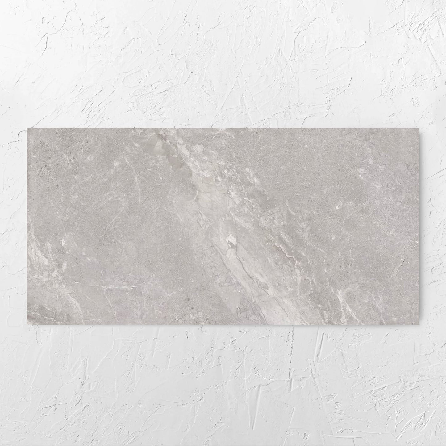 Alpen Stone Grey Lappato 600x1200mm tile laid flat on a white rendered wall, showing the tile surface