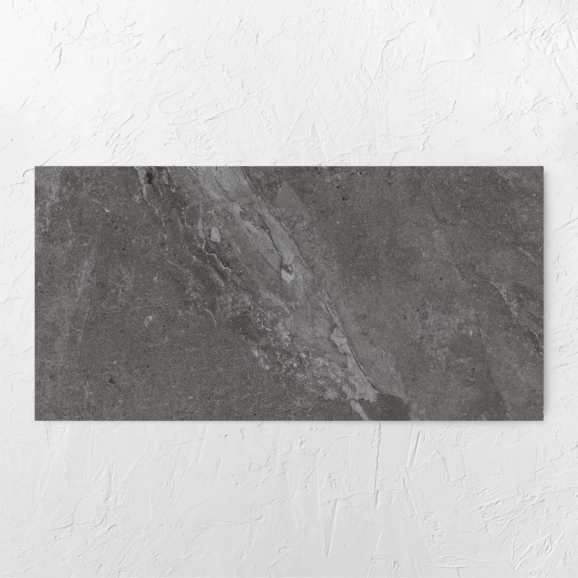 Alpen Stone Smoke 600x1200mm tile laid flat on a white rendered wall, showing the smoke surface
