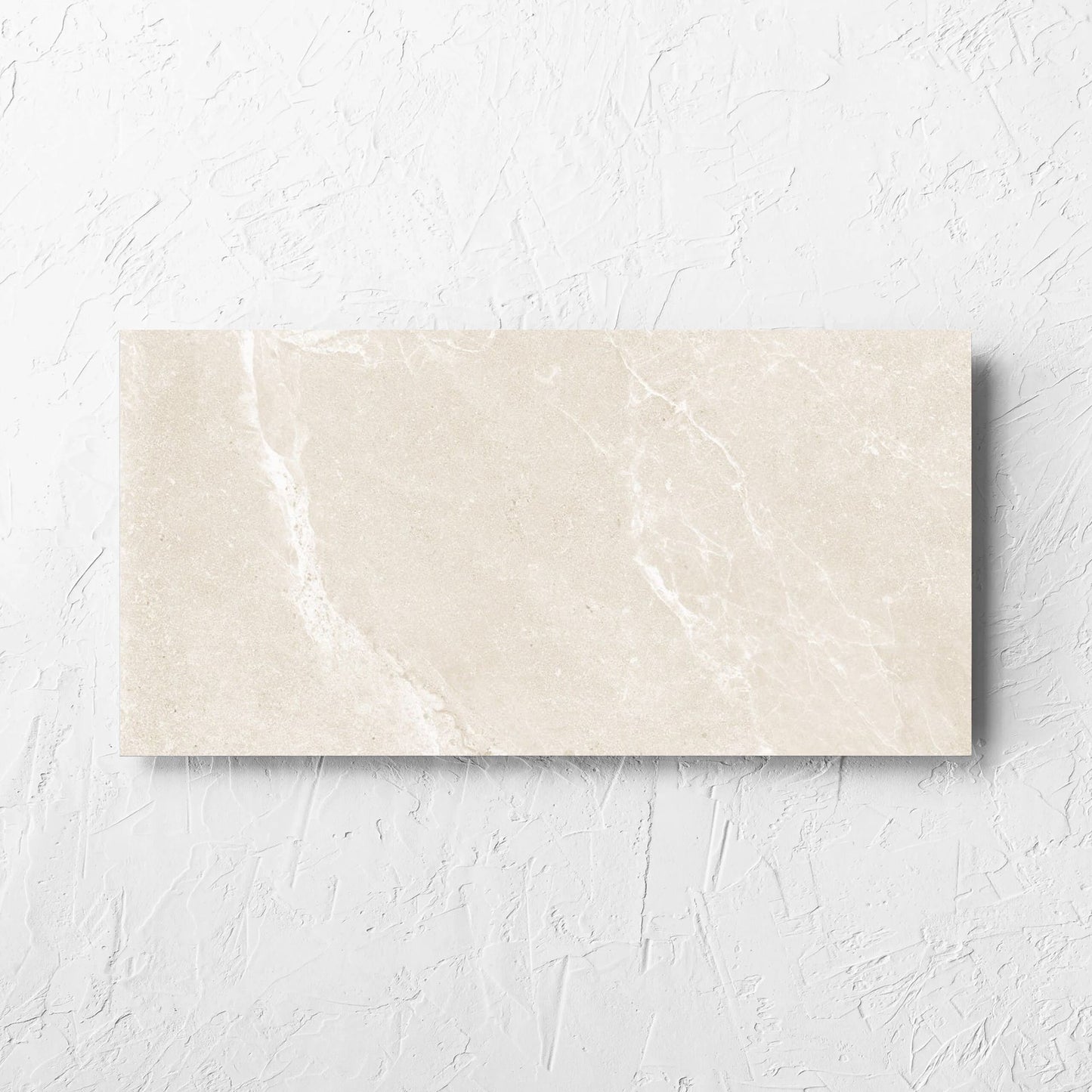 Alpen Stone Warm 300x600mm tile laid flat on a white rendered wall, showing the tile surface