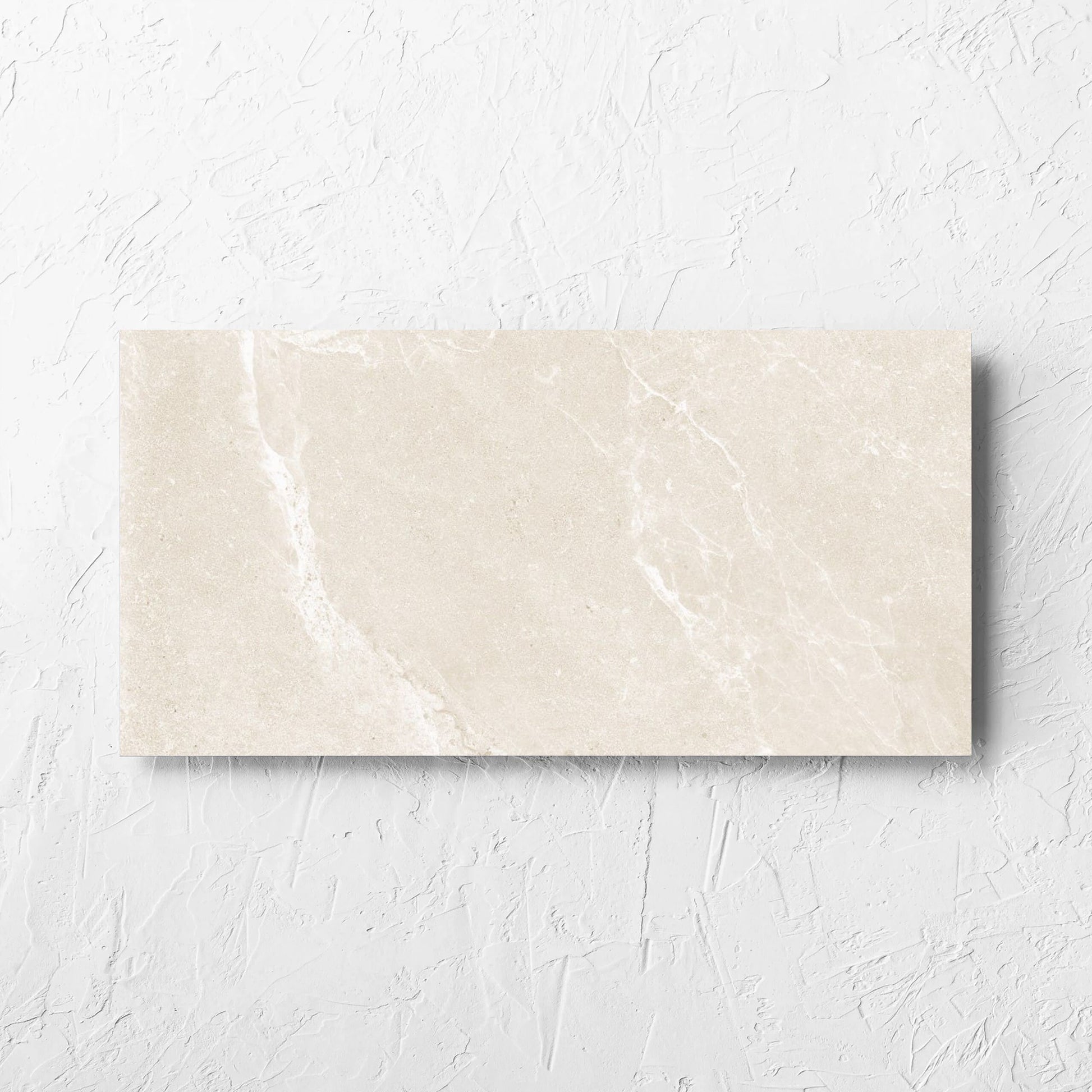 Alpen Stone Warm 300x600mm tile laid flat on a white rendered wall, showing the tile surface