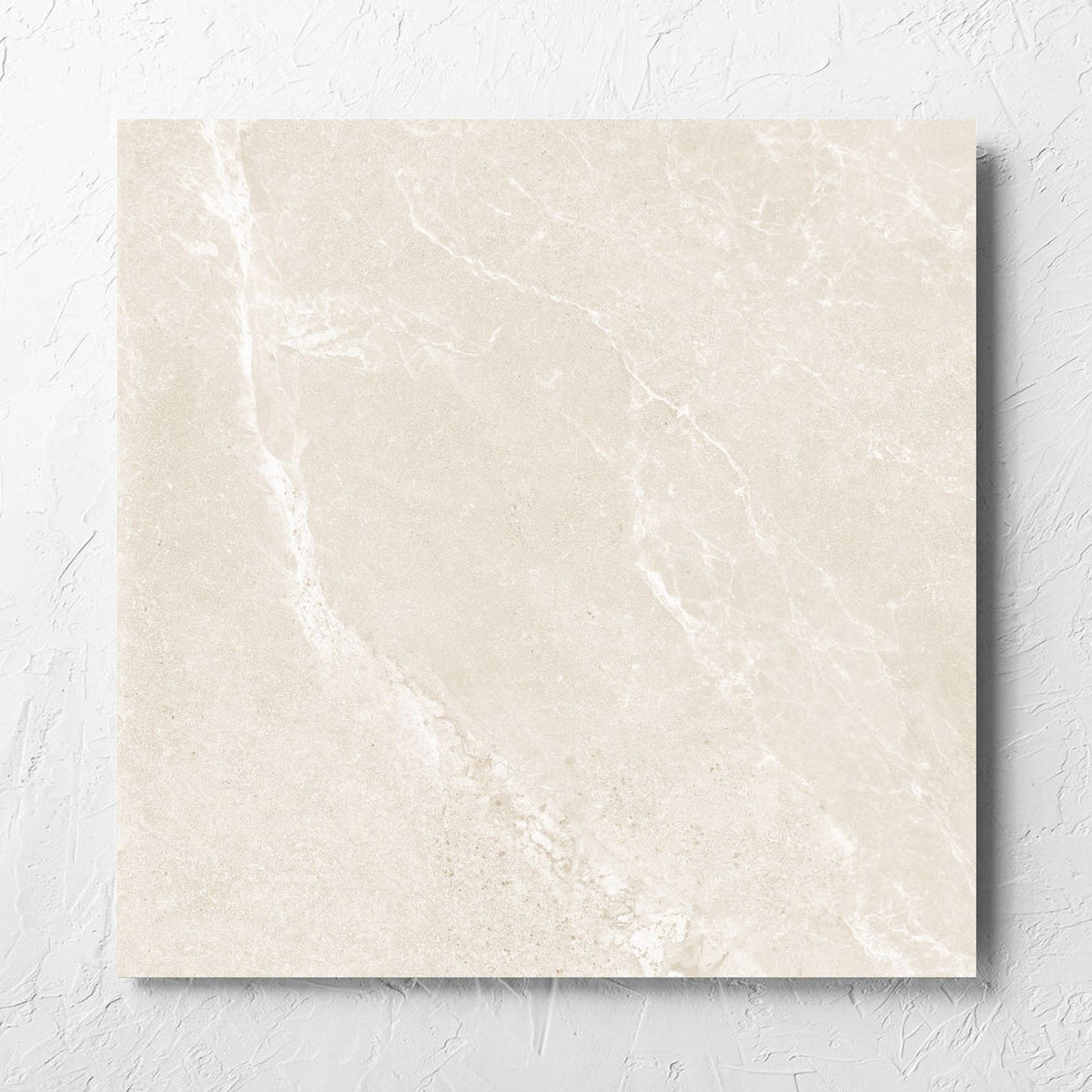 Alpen Stone Warm 600x600mm tile laid flat on a white rendered wall, showing the tile surface