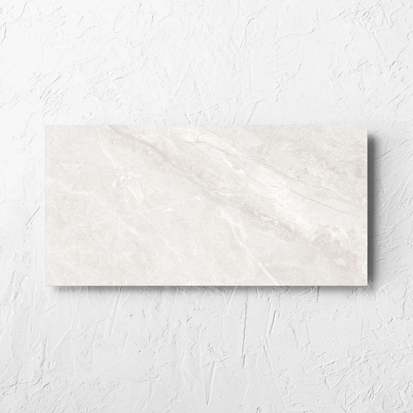 Alpen Stone White 300x600mm tile laid flat on a white rendered wall, showing the white surface