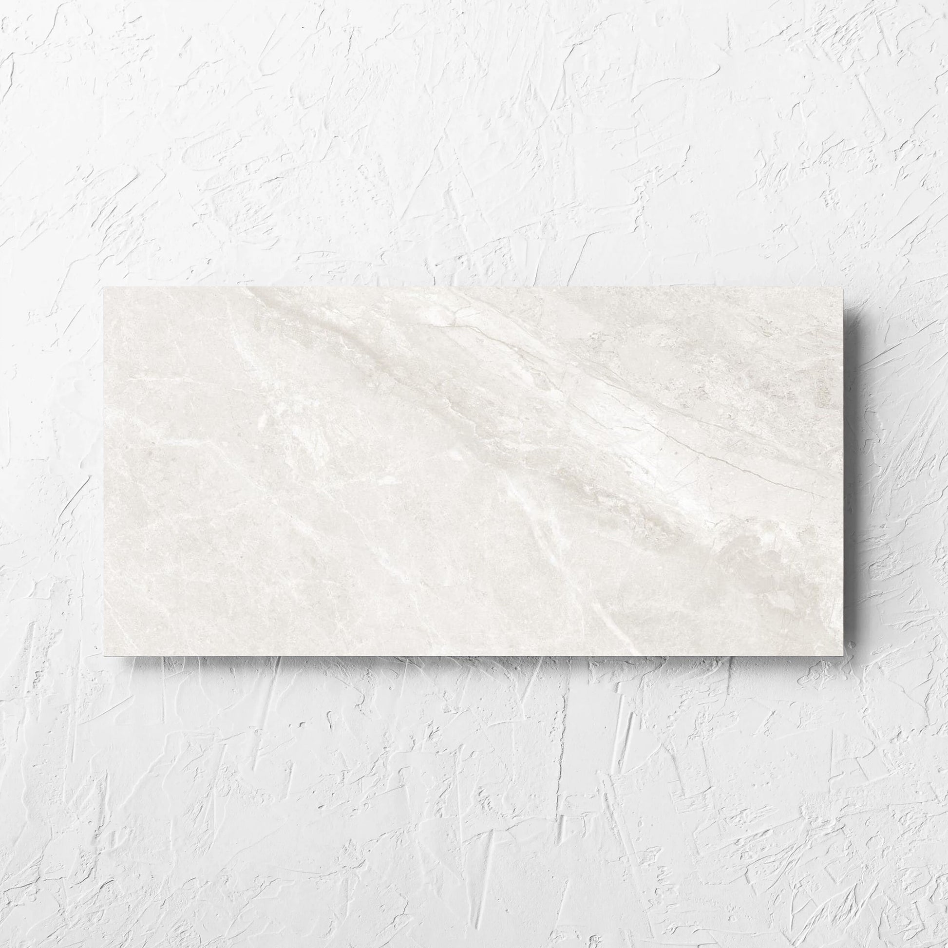 Alpen Stone White 300x600mm tile laid flat on a white rendered wall, showing the white surface