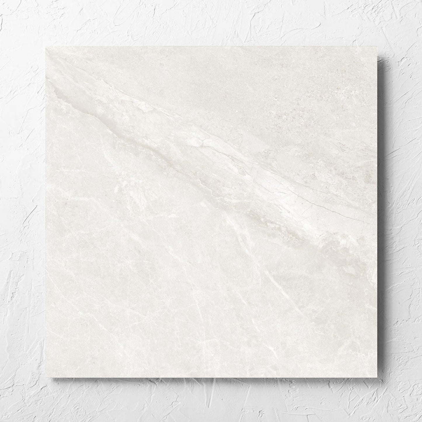 Alpen Stone White 600x600mm tile laid flat on a white rendered wall, showing the tile surface