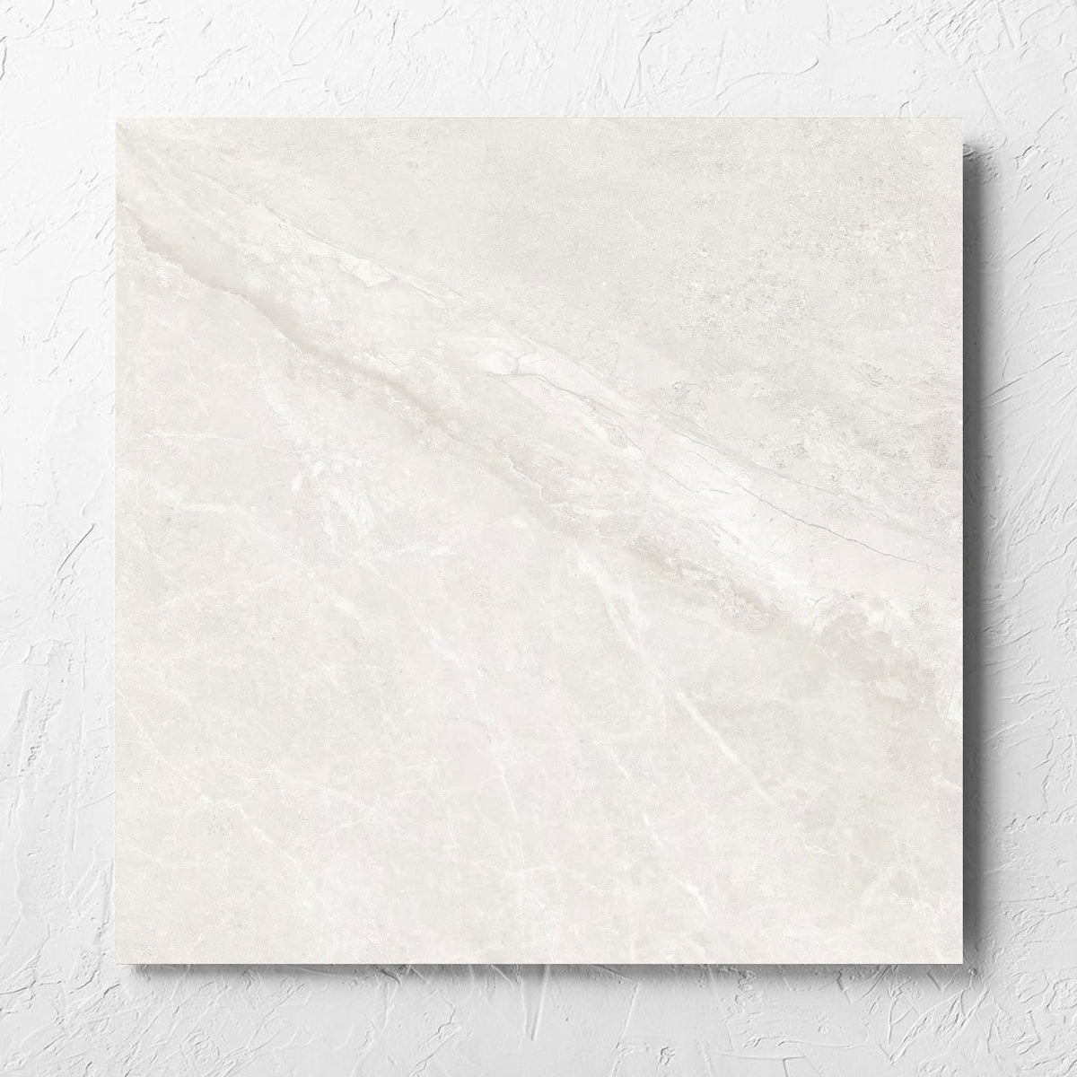 Alpen Stone White Lappato 600x600mm tile laid flat on a white rendered wall, showing the tile surface
