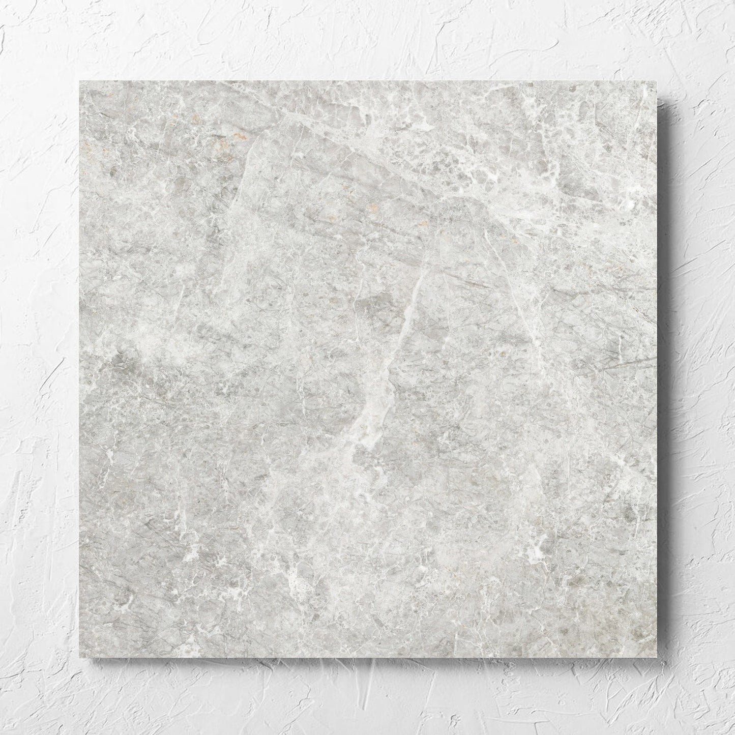 Antalya Beige Amber 600x600mm tile laid flat on a white rendered wall, showing the matt surface