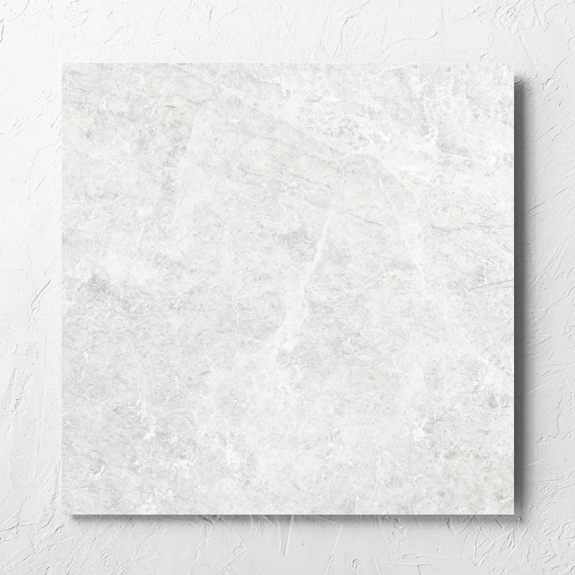 Antalya Bianco Matt 600x600mm tile laid flat on a white rendered wall, showing the matt surface