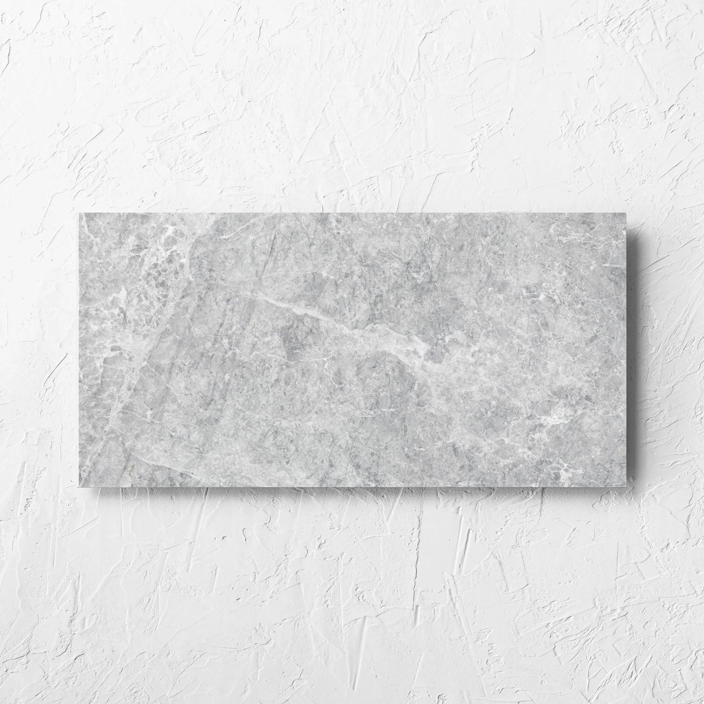 Antalya Silver Matt 300x600mm tile laid flat on a white rendered wall, showing the matt surface