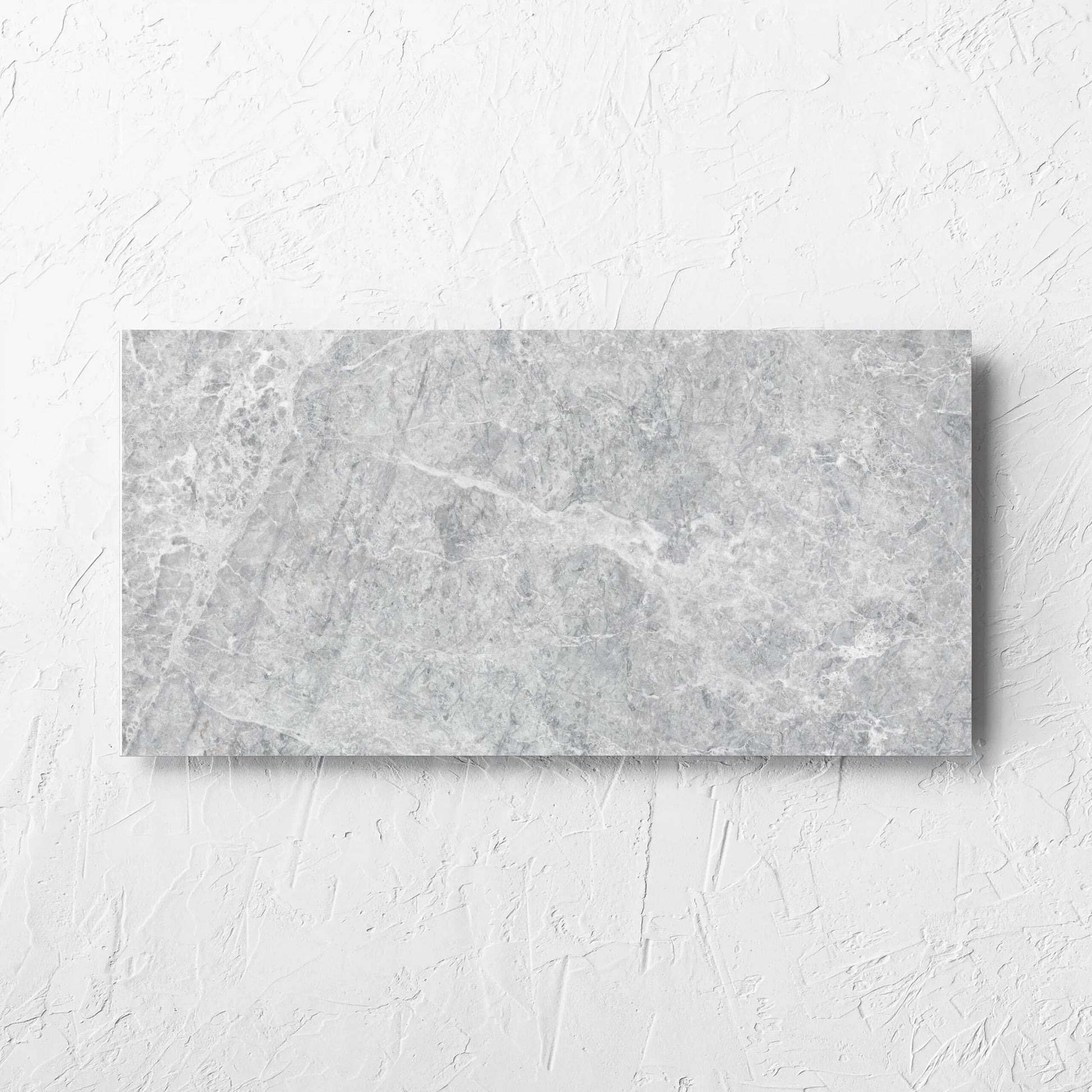 Antalya Silver Matt 300x600mm tile laid flat on a white rendered wall, showing the matt surface