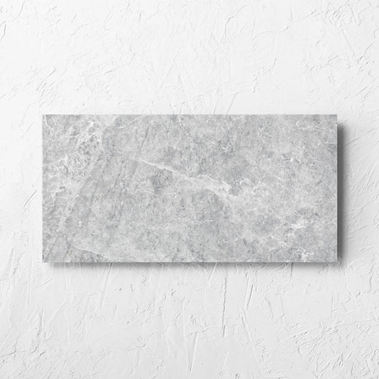 Antalya Silver Matt 300x600mm tile laid flat on a white rendered wall, showing the matt surface