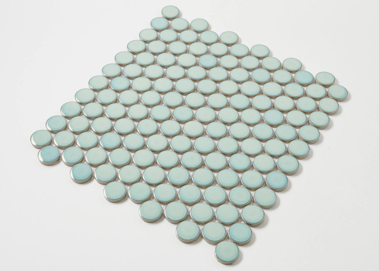 A diamond-shaped mosaic sheet of Antique Green Gloss Glazed Porcelain Penny Round 28mm Diameter tiles displaying a soft mint-green glazed finish arranged in neat circular rows.
