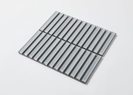 Pack shot of Antique Grey Speckled Gloss Concave Porcelain Glazed Finger 20x145mm tiles arranged in a square sheet, showing their pale grey glazed concave surface with subtle speckled texture.