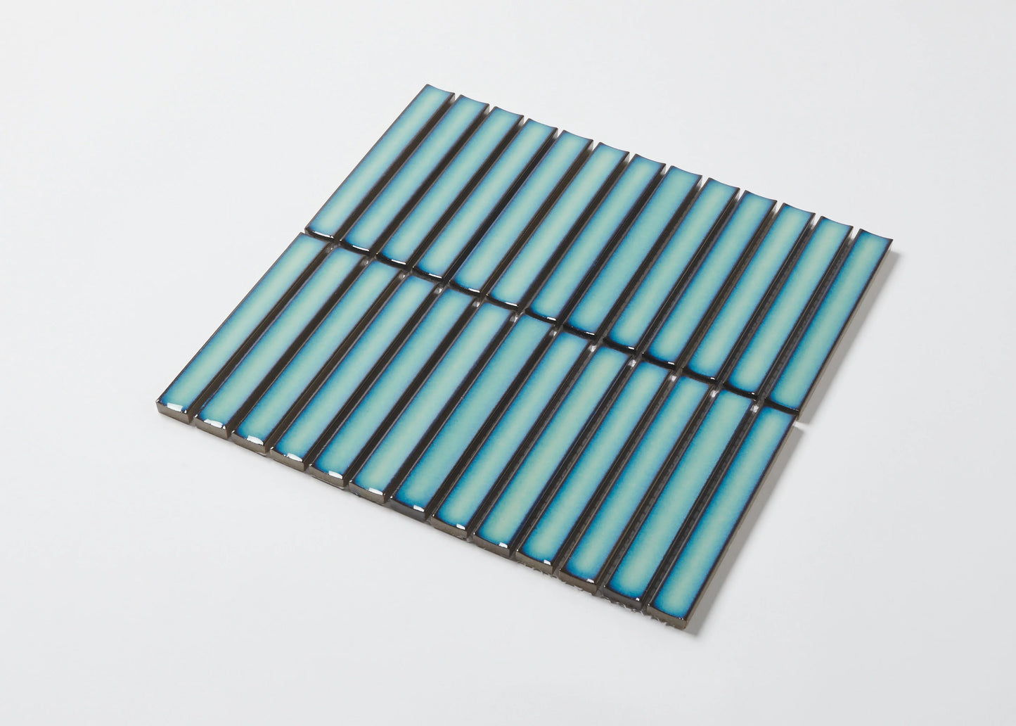 Pack shot of Antique Medium Green Gloss Concave Porcelain Glazed Finger 20x145mm tiles arranged in a flat grid, showcasing their elongated concave profile and blue-green gloss finish.