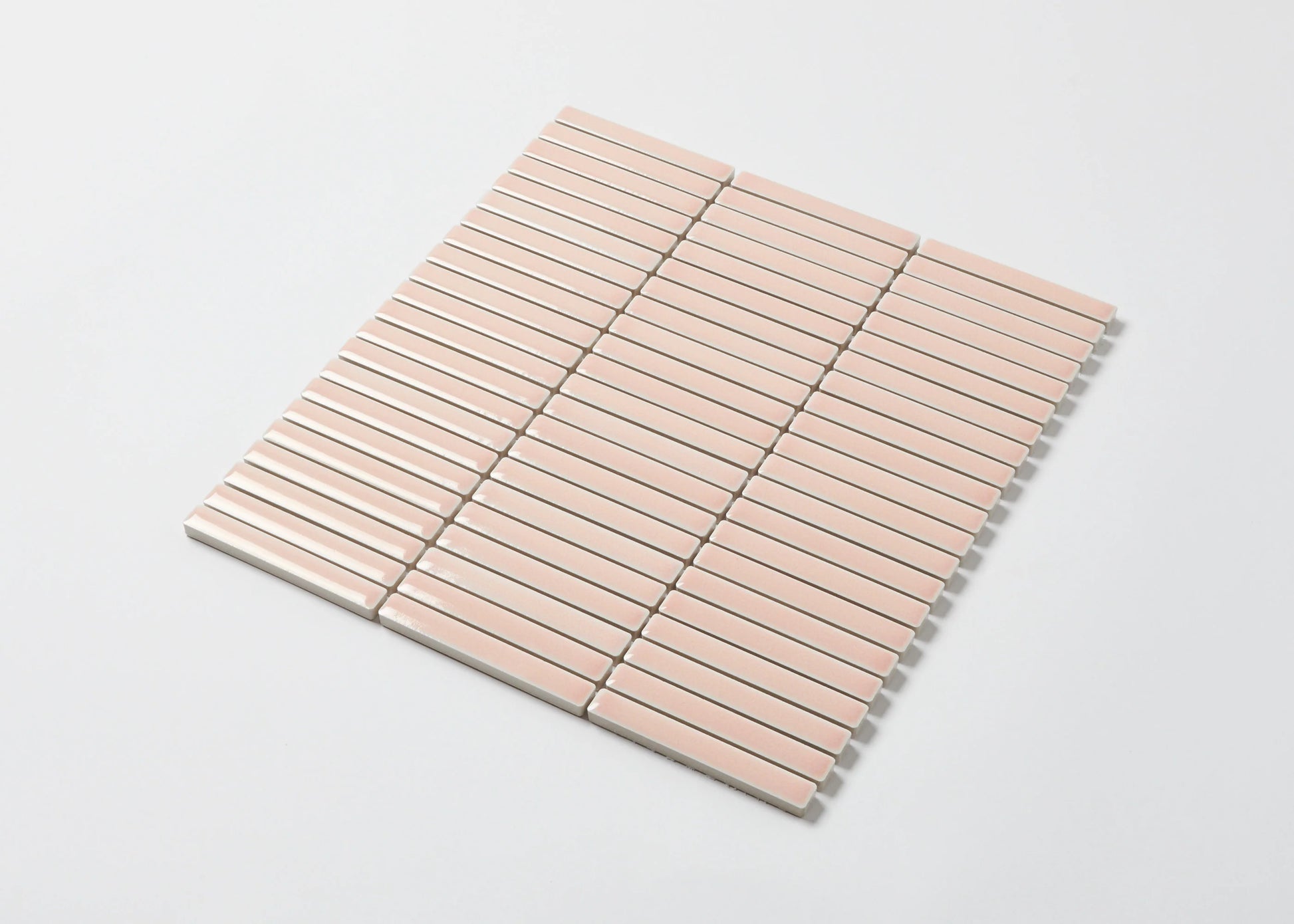 Pack shot of Antique Pale Pink Gloss Porcelain Glazed KitKat 12x92mm mosaic sheet showing glossy blush pink elongated finger tiles arranged in a uniform horizontal stack bond pattern.