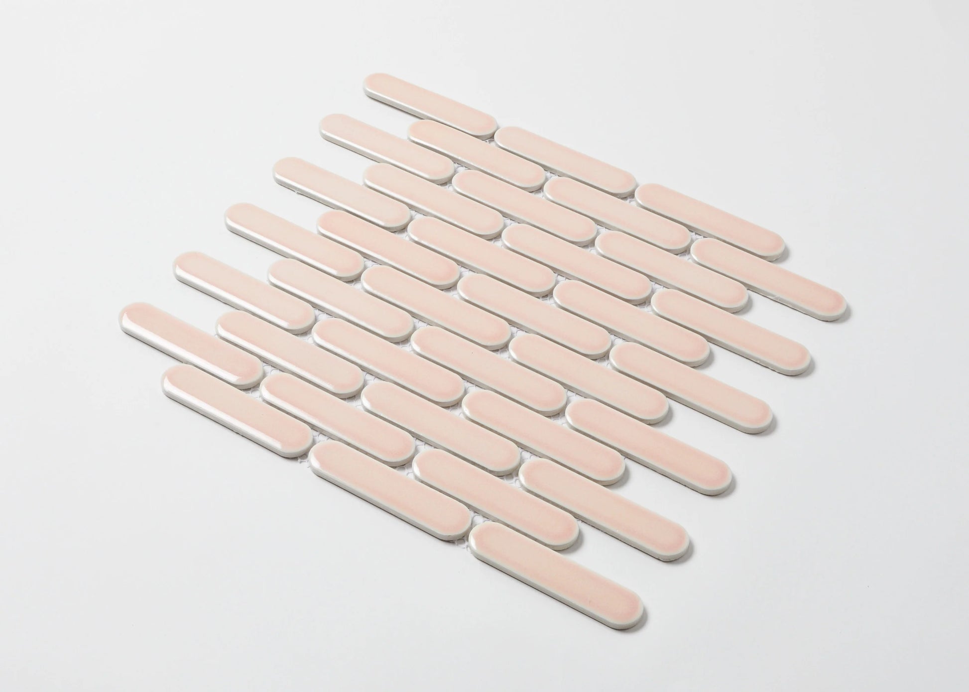Pack shot of Antique Pink Gloss Round Head Finger Glazed Mosaic 23x93mm tiles arranged in a staggered diagonal pattern with white grout joints on a light background.