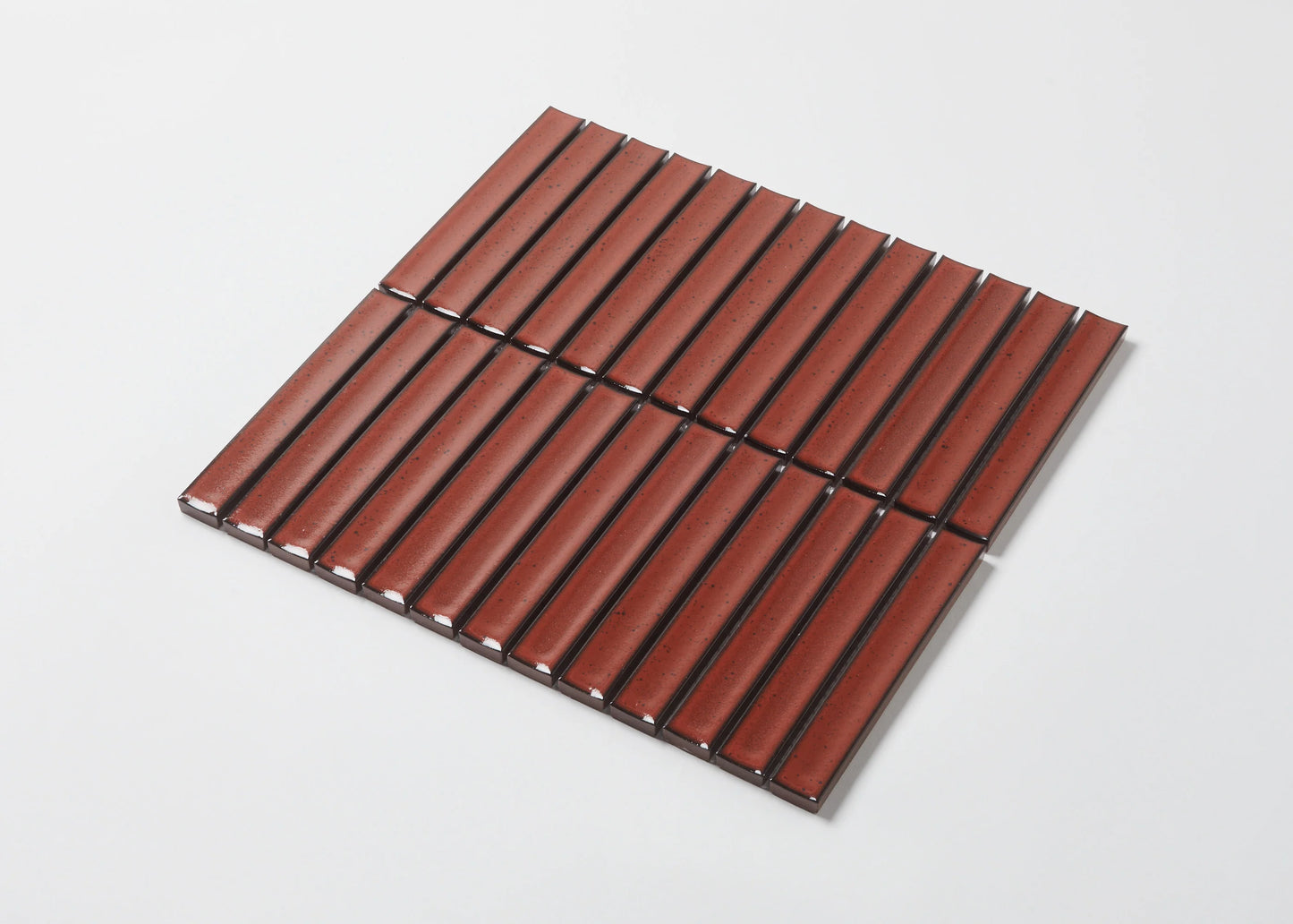 Pack shot of Antique Terracotta Red Speckled Gloss Concave Porcelain Glazed Finger 20x145mm tiles arranged in a flat lay grid showing the ribbed concave surface, warm red speckled glaze, and dark grout lines.