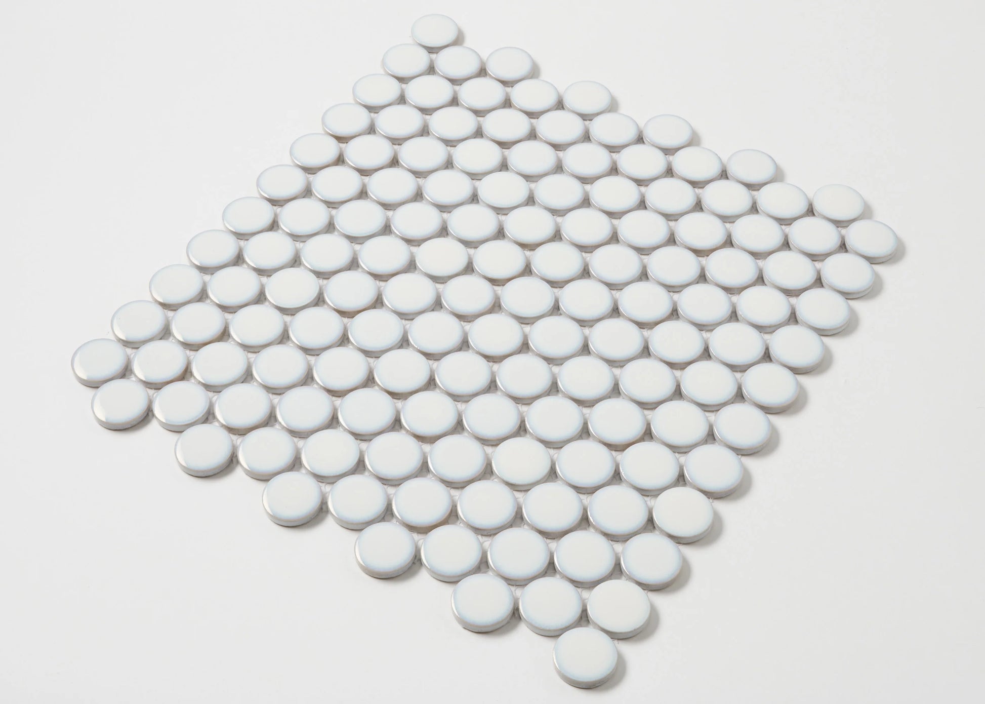 A flat-lay pack shot of Antique White Gloss Glazed Porcelain Penny Round 28mm Diameter mosaic tiles arranged in a diamond-shaped sheet showing their circular glossy finish.